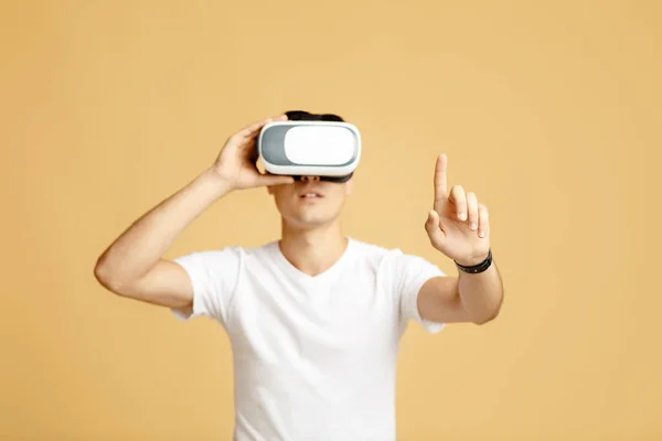 Man in vr glasses playing games with virtual reality headset trying to touch something with finger — Stock Photo, Image