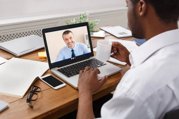 Geschäftsmann am Laptop mit Online-Treffen mit Mitarbeiter am Arbeitsplatz — Stockfoto