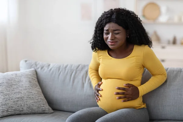 Femme enceinte noire souffrant de douleurs de travail à la maison — Photo