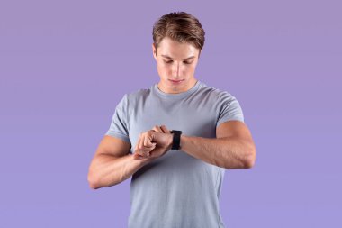 Güçlü atletik adam Violet stüdyosunun arka planındaki akıllı bakışlarına bakıyor.