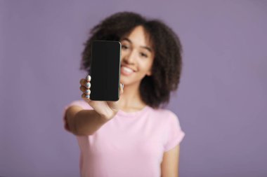 Pozitif ifade. Pembe tişörtlü, kıvırcık saçlı neşeli bir kadın.