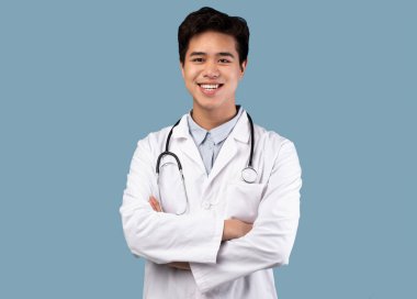 Kameraya poz veren Asyalı doktor.