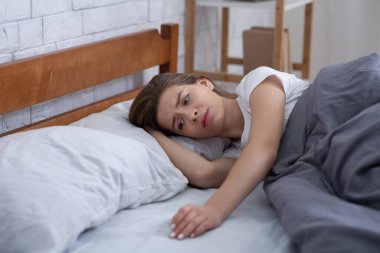 Sevdiği kişinin kaybından muzdarip üzgün genç bayan evdeki yatağını okşuyor, boşluğu dolduruyor.