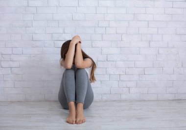 Umutsuz bir milenyum kadını, duvarın yanında oturmuş umutsuzluktan, boşluktan ağlıyor.