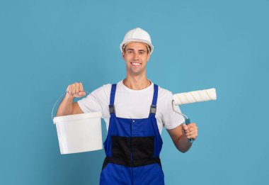 Ressam adam. Gülümseyen Erkek Tamir Ustası Boya için Kova ve Ekipman tutuyor