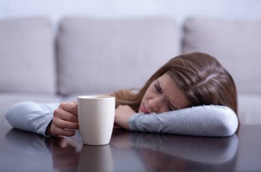 Sorunlu genç bayan sıcak bir içecek ile yalnız ve üzgün hissediyor, depresyondan muzdarip
