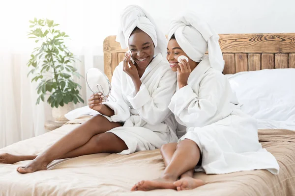 बाथरोब मध्ये आफ्रिकन अमेरिकन महिला मित्र घरी चेहरे स्वच्छता — स्टॉक फोटो, इमेज