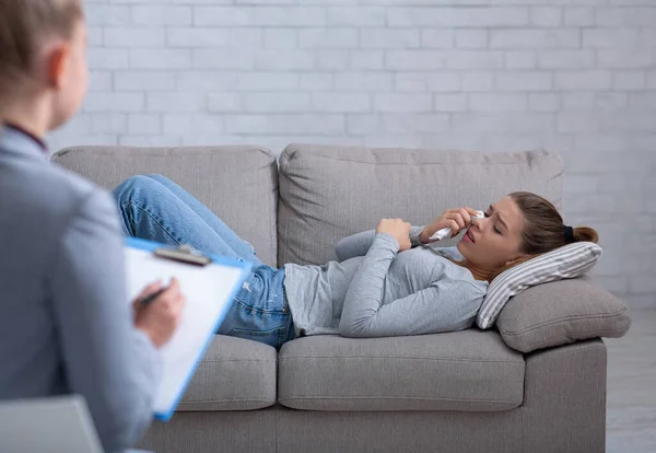 Wanita muda yang tertekan berkonsultasi dengan psikolog, berbaring di sofa dan menangis — Stok Foto