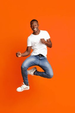 Zenci adam havaya atlıyor ve komik figürler gösteriyor.