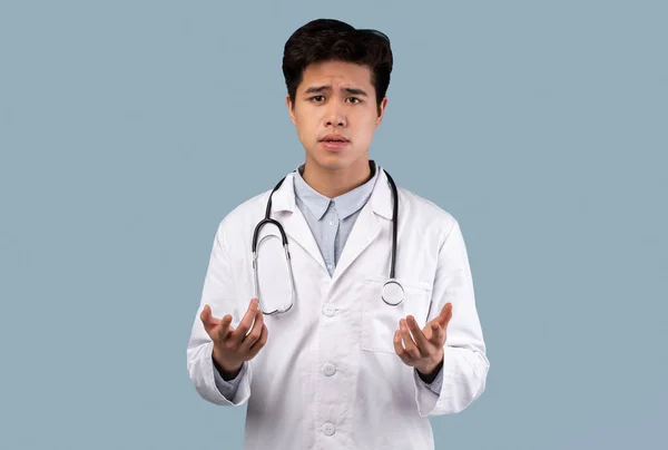 Asiat v lékařském kabátě mluví s kamerou, gestikuluje — Stock fotografie