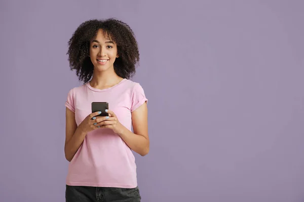 Modern öğrenci blogcuları internette arama yapıyor. Gülümseyen milenyum Afrikalı Amerikalı kadın elinde telefonla — Stok fotoğraf