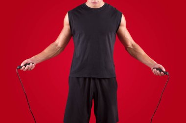 Kardiyo çalışması. Kırmızı stüdyo arka planında atlayan milenyum sporcusunun kırpılmış görüntüsü.