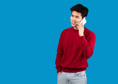 Asyalı adam cep telefonuyla konuşuyor, kopyalama alanına bakıyor.