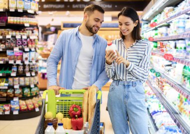 Genç mutlu çift süpermarketten alışveriş yapıyor.