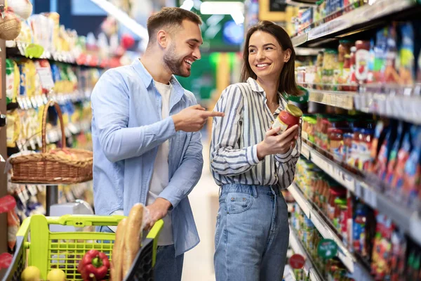 Young happy couple with the cart shopping in supermarket — Stock Photo, Image
