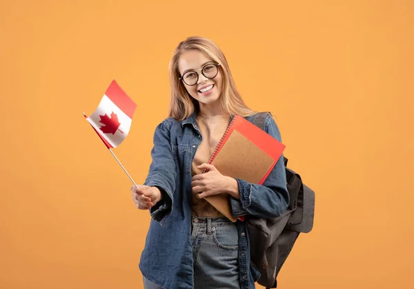 Canada day, holiday, confederation anniversary. Cheerful teen blonde female in glasses