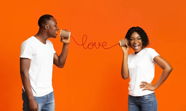 Afrikalı adam mutlu kız arkadaşına sevgi dolu sözler söylüyor. — Stok fotoğraf