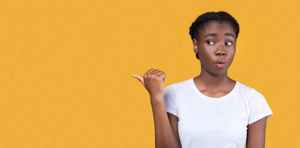African Lady indicando pollice oltre Posa su sfondo giallo, Panorama — Foto Stock