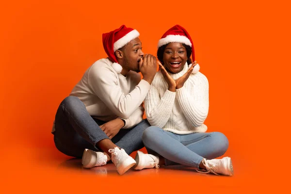 Αγαπάει τον μαύρο που ψιθυρίζει Χριστουγεννιάτικο μυστικό στην ενθουσιασμένη φιλενάδα του. — Φωτογραφία Αρχείου