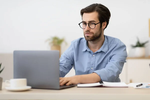 Empresário franzido trabalhando em laptop com tarefa difícil no local de trabalho — Fotografia de Stock