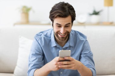 Ev telefonundaki kulaklıkla video görüşmesi yapan adam.