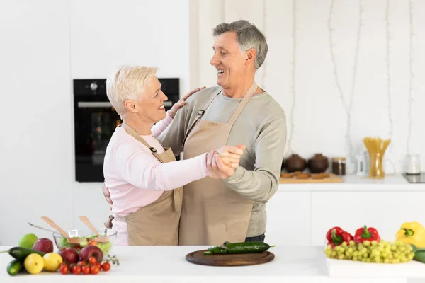 Los cónyuges mayores bailan en la cocina moderna en casa el fin de semana —  Fotos de Stock