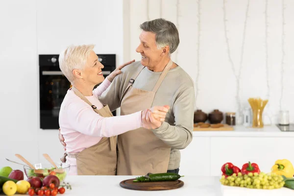 Весела літня пара танцює на кухні розважається вдома — стокове фото