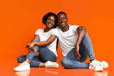 Kaygısız Afrikalı Amerikalı aşıklar yerde oturuyor, stüdyo çekimi.