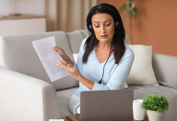 Woman in headset sitting at desk, having videocall on computer — Stock Photo, Image