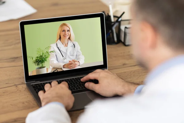 Online medicine concept. Male patient having video conference with professional doctor on laptop from home — Stock Photo, Image