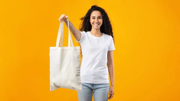 Femme montrant éco sac blanc debout sur fond blanc studio — Photo