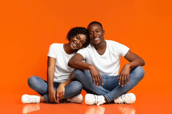 Belo casal afro-americano sentado no chão e abraçando — Fotografia de Stock