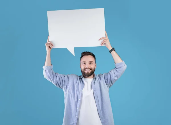 Glücklicher Millennial-Mann mit leerer Sprechblase über dem Kopf über blauem Studiohintergrund, Kopierraum — Stockfoto