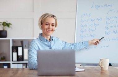 Genç üniversite öğretmeni evden matematik dersi veriyor, üniversite öğrencilerine logaritmaları anlatıyor.