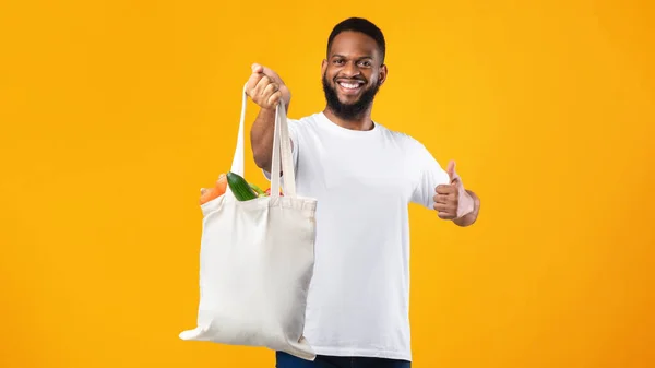 Homem africano segurando Eco saco Gesturing como, fundo amarelo — Fotografia de Stock