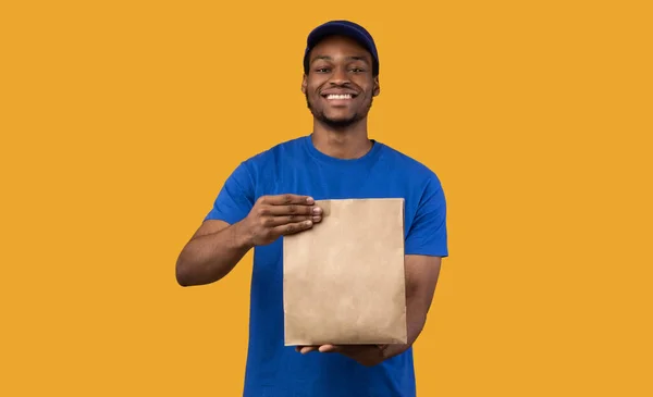 Gelukkig lachende zwarte levering guy holding pakket — Stockfoto