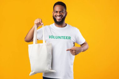 Afrikalı Erkek Gönüllü Sarı Arkaplanda Eko Poşet Gösteriyor