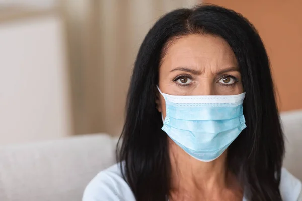 Portret van een serieuze vrouw met gezichtsmasker om infectie te voorkomen — Stockfoto