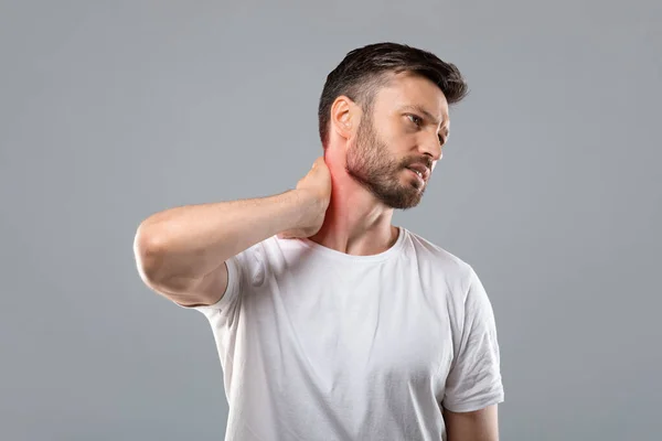 Man met baard van middelbare leeftijd die zijn ontstoken nek aanraakt — Stockfoto