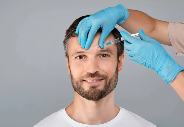 Atractivo hombre de mediana edad recibiendo elevación de la frente —  Fotos de Stock