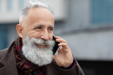 Telefonda konuşan neşeli son sınıf öğrencisinin yakın çekimi.