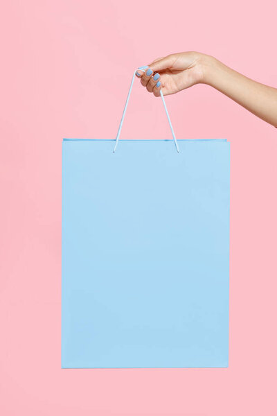 Рука африканской девушки-подростка с голубой сумкой для покупок