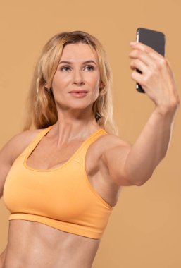 Güzel vücut geliştirici eğitmeni blog ya da sosyal medya için fotoğraf çekiyor