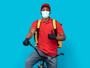Siyah bisikletli teslimatçı başparmağını kaldırıyor.
