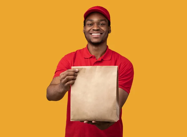 Feliz sonriente negro entrega hombre celebración paquete — Foto de Stock