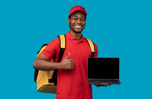 흉내를 내기 위해 빈 화면이 있는 노트북을 들고 있는 흑인 택배 원 — 스톡 사진