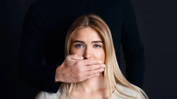 Cállate y escucha. La mano masculina cierra la boca de la mujer y le impide hablar de sentimientos — Foto de Stock