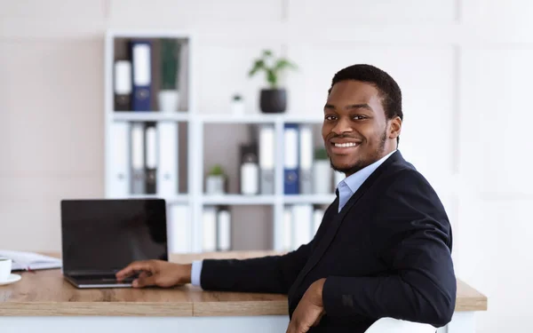 Succesvolle Afro-Amerikaanse zakenman poserend in zijn kantoor, panorama — Stockfoto