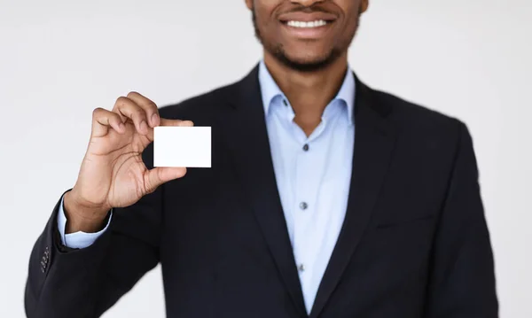 Hombre de negocios negro entregando tarjeta de visita en blanco sobre fondo blanco —  Fotos de Stock