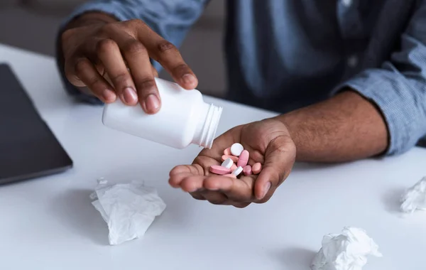 Primer plano de las píldoras médicas en la mano del hombre negro, recortado — Foto de Stock